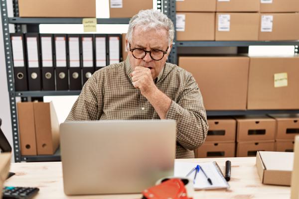 Man coughing at desk