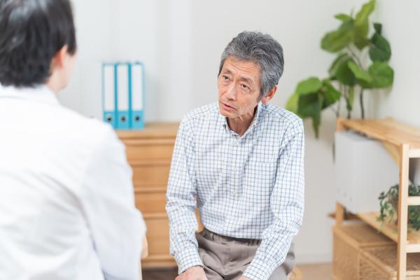 Frail asian man in medical consultation with GP