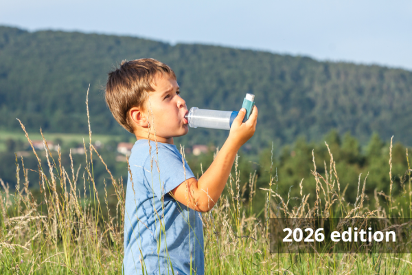 Young child in an open field using an inhaler with spacer