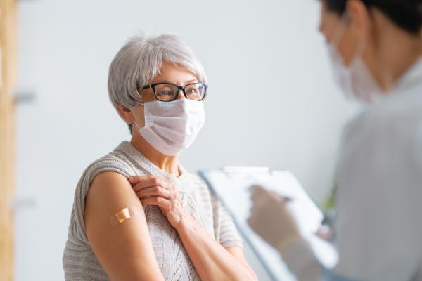 Patient with mask on being vaccinated