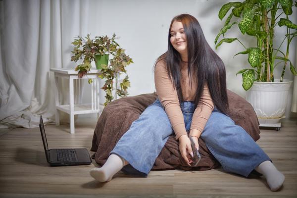 Stylish chubby female student with type 2 diabetes sitting on a bean bag