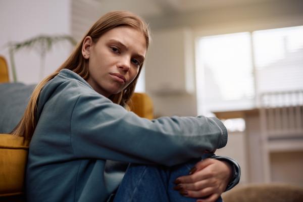 young lady sitting on the floor looking directly at the camera