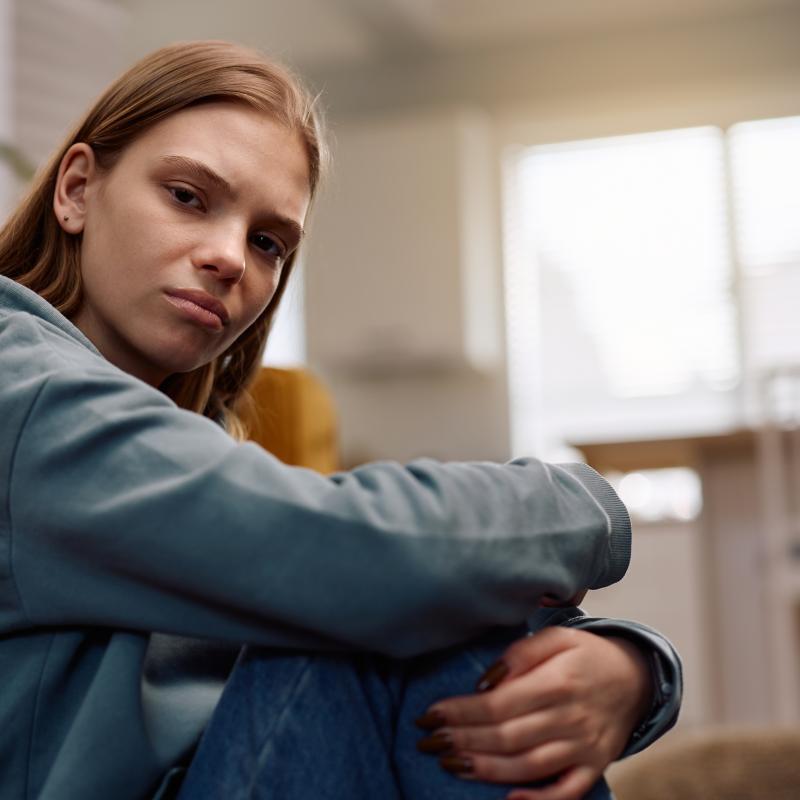 young lady sitting on the floor looking directly at the camera