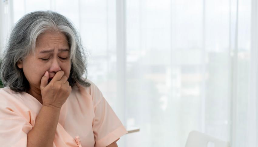 Woman coughing into her hand
