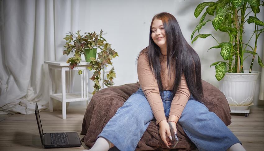 Stylish chubby female student with type 2 diabetes sitting on a bean bag