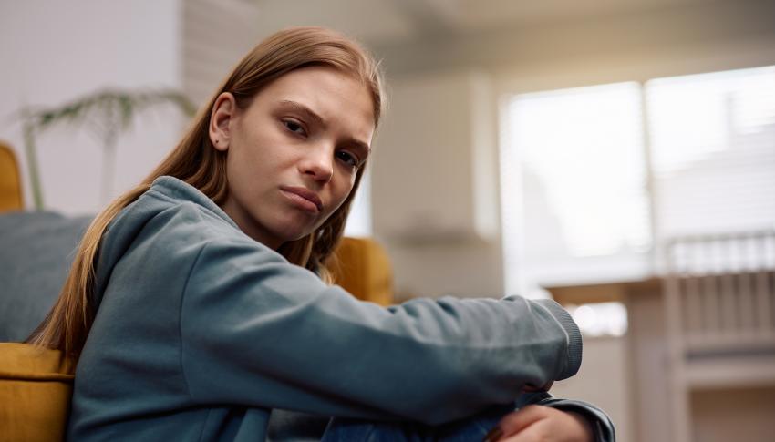 young lady sitting on the floor looking directly at the camera