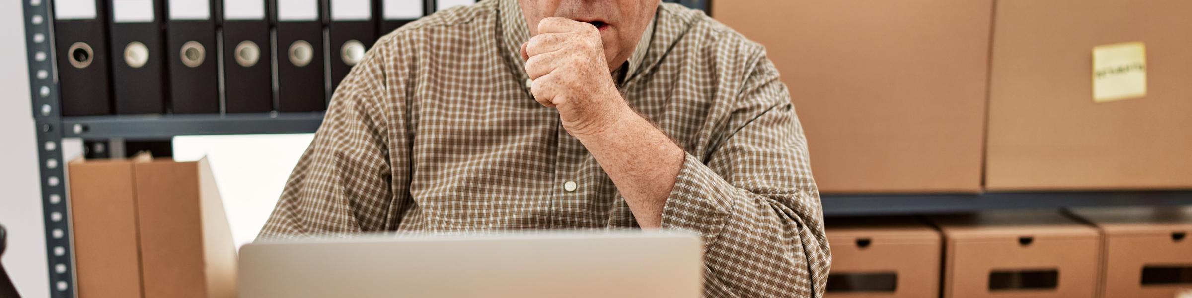 Man coughing at desk