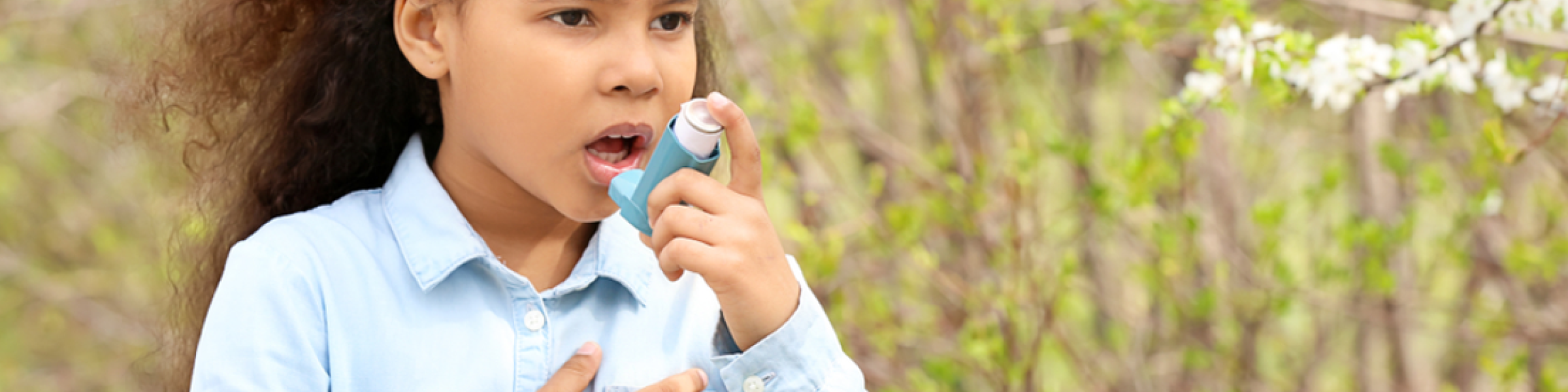 Child in a forest using an inhaler