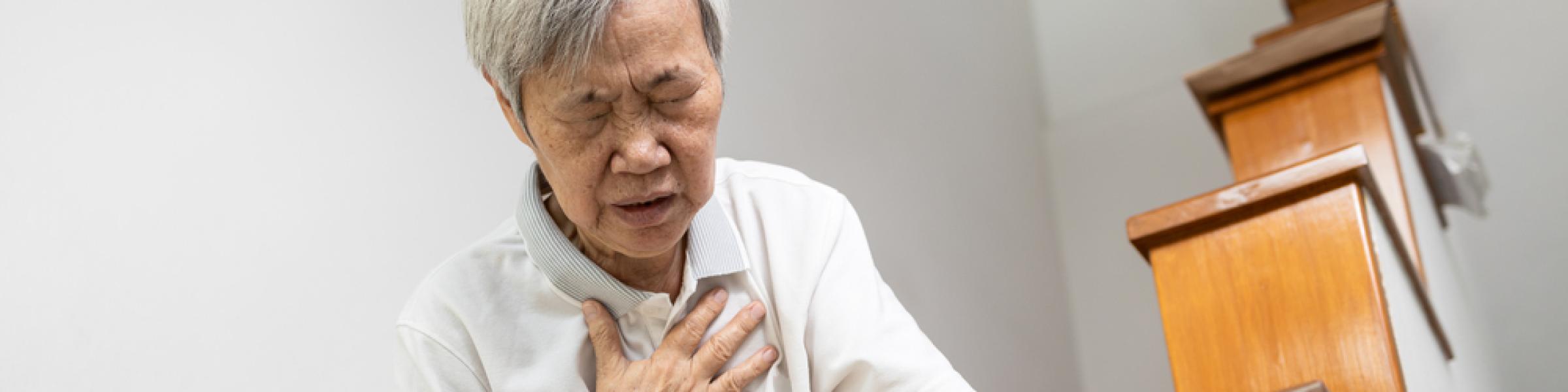 Asian woman clutching chest