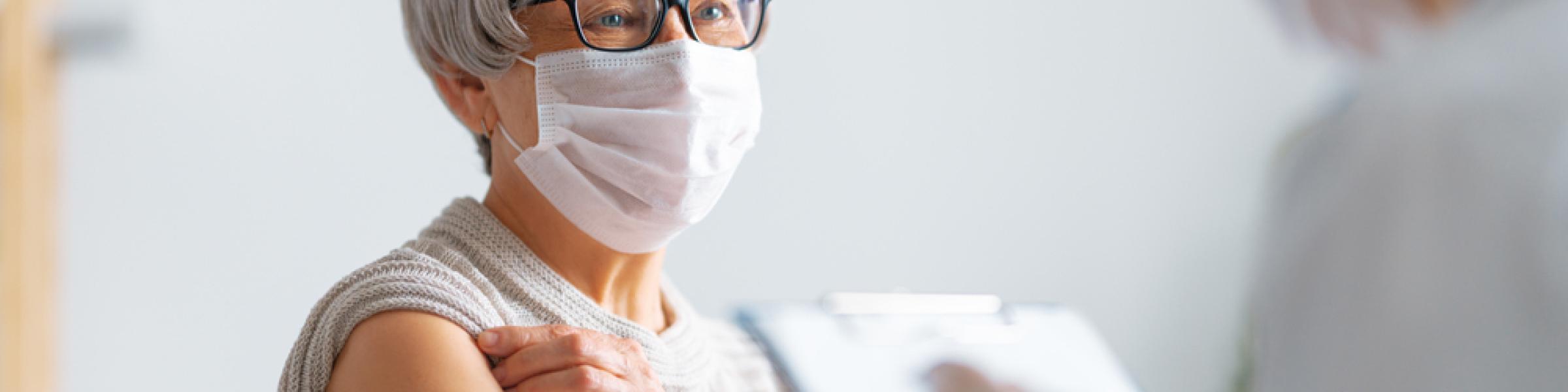 Patient with mask on being vaccinated