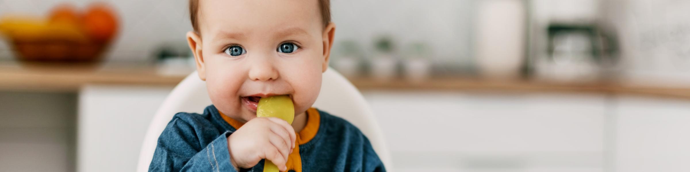 Baby with yellow spoon in mouth