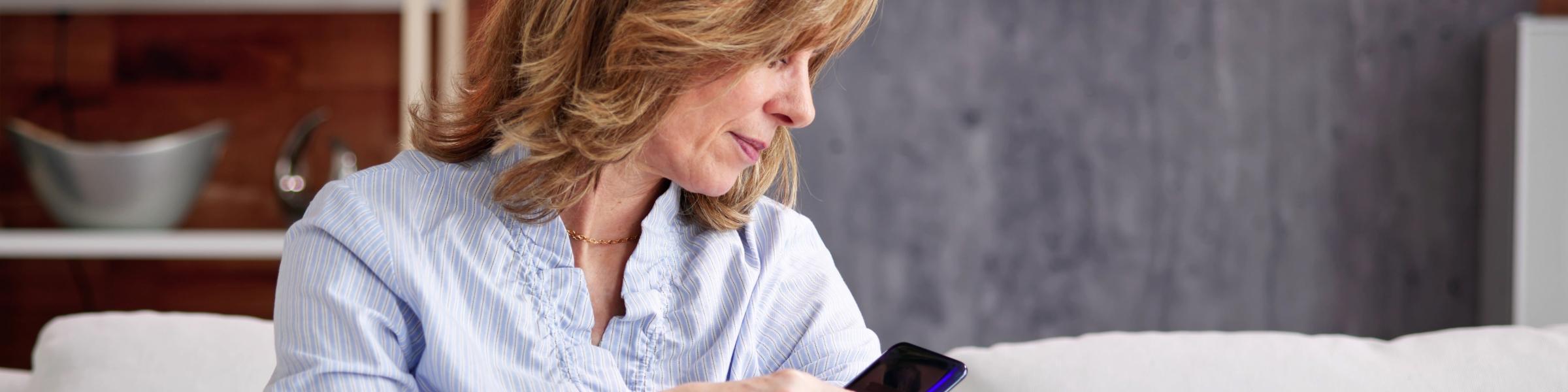 Image of woman checking a continuous glucose monitor with her mobile phone