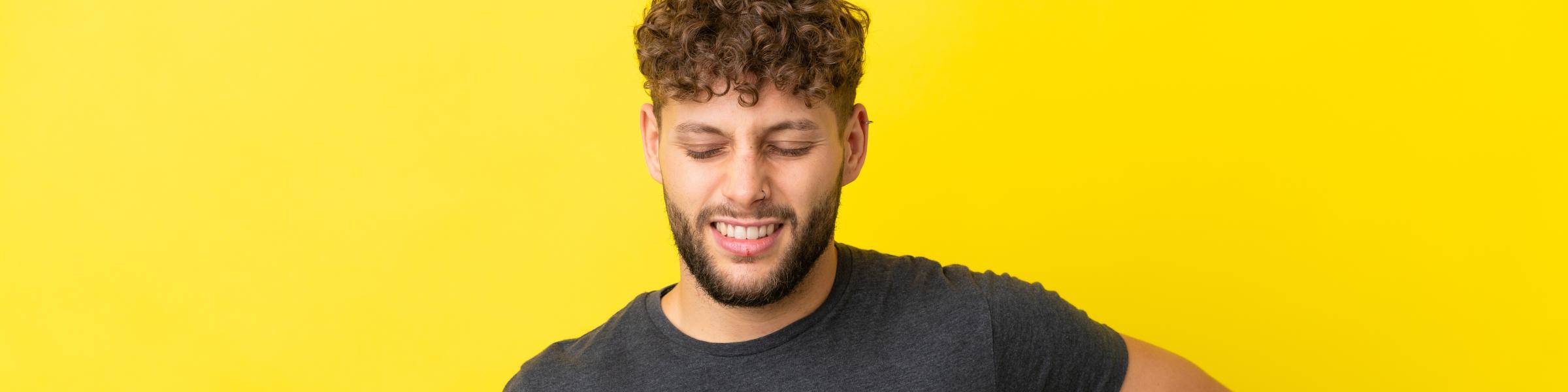 man with a soccer ball experiencing back pain