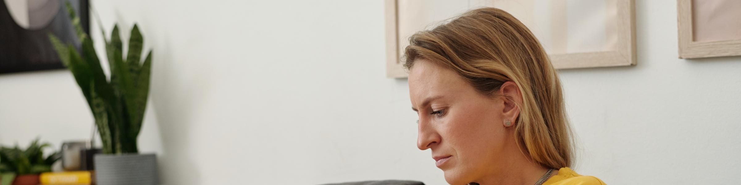 Woman wearing a CGM checking her blood glucose level on her mobile phone