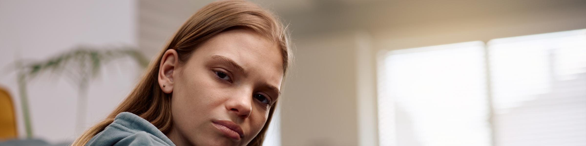 young lady sitting on the floor looking directly at the camera