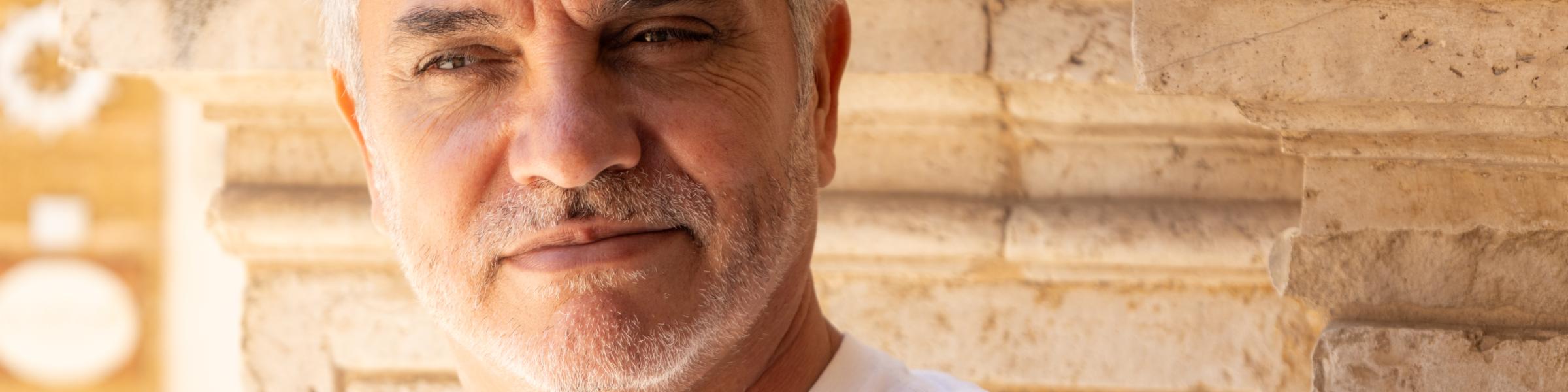headshot of an old man in white shirt