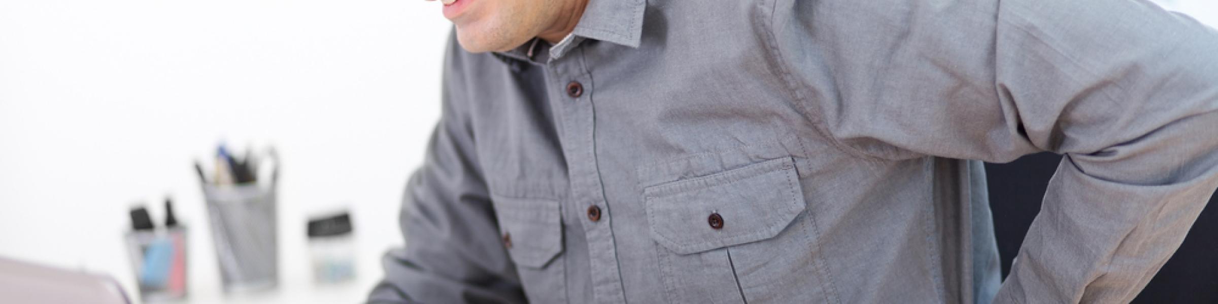 Man holds his back in a state of pain